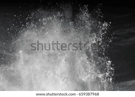 Freeze motion of white dust explosion on black background. Stopp