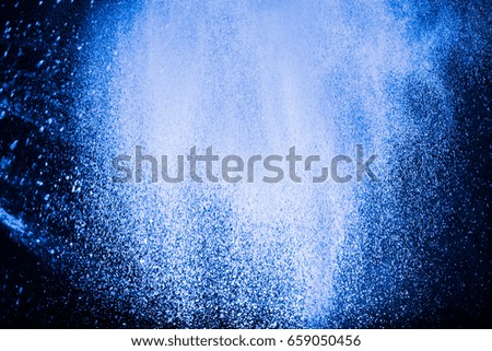 Freeze motion of white particles on black background.