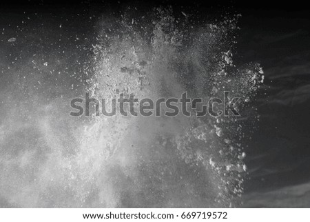 Freeze motion of white particles on black background. Powder explosion. Abstract dust overlay texture.  