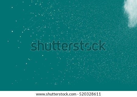 Freeze motion of white powder coming down, isolated on color background. Abstract design of falling dust cloud. Particles cloud screen saver, wallpaper with copy space. Rain, snow fall concept