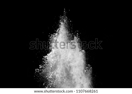 Freeze motion of white powder explosion on black background.