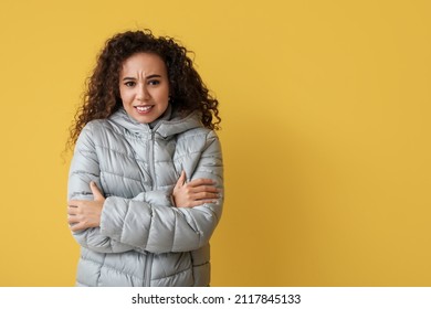 Freezing African-American Woman In Winter Clothes On Color Background