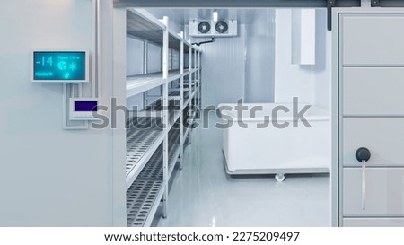 Freezing chamber at enterprise. Storage room with minus temperature. Freezing chamber at pharmacological factory. Entrance to large refrigerator. Freezing chamber with racks along wall. 