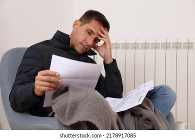 Freezing man holding bills for electricity, gas and heating. Global energy crisis concept. Cold home, Global energy crisis concept - Shutterstock ID 2178917085