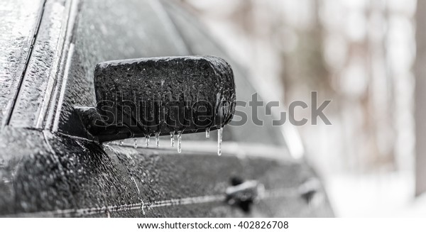 freezing rain ice coated car.  Black vehicle car\
covered in freezing rain, Icicles hanging from side mirror.  bad\
driving weather in freezing\
rain.