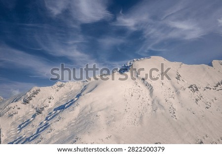  The freezing wind blowing hard between the rocks and snow