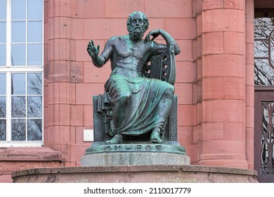 Freiburg Im Breisgau, Germany. Homer Statue In Front Of The Main Building Of The Albert Ludwig University Of Freiburg. The Statue Was Erected In 1921. Greek Text On Plinth Means Homer.