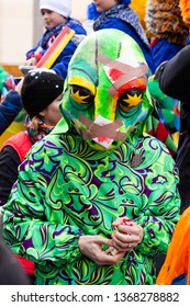 Freie Strasse, Basel, Switzerland - March 12th, 2019. Close-up Of A Green Lizard Carnival Costume And Mask