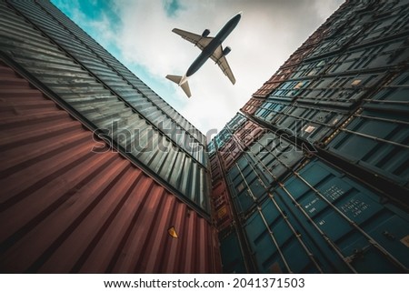 Freight airplane flying above overseas shipping container . Logistics supply chain management and international goods export concept .