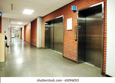 Freight And Regular Steel Door Elevators With Signs In An Empty Hallway Of Modern Building. Can Be Office, School, Hospital.