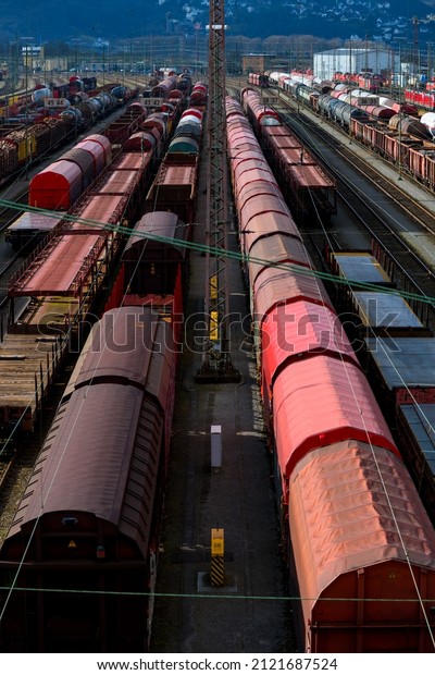 Freight station shunting yard panorama in\
Hagen-Vorhalle Germany. Symmetric view from a bridge with dozens of\
different red and brown wagons. Transportation and logistics with\
railway freight cars.