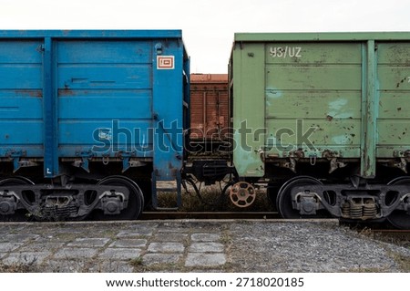 Freight train cargo wagons on railway tracks. Industrial rail transport scene showing goods transportation, logistics and heavy infrastructure in close-up side view.
