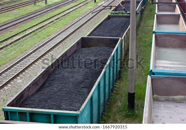  Freight train with coal, top view. rail\
cars loaded with coal. Transportation of coal in commodity cars.\
Railway stretches into distance. Formation of coal trains in a\
freight depot. metallurgical
