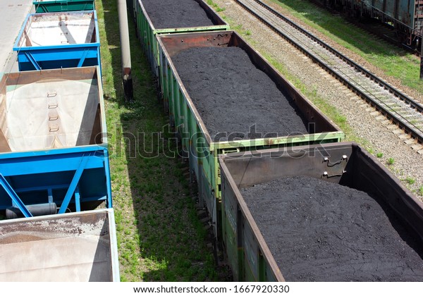  Freight train with coal, top view. rail cars\
loaded with coal. Transportation of coal in commodity cars. Railway\
stretches into distance. Formation of coal trains in a freight\
depot. mining. mineral