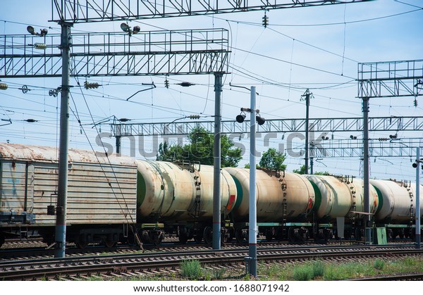 Freight train crossing through railroad\
station. Railway freight cars and tank\
cars