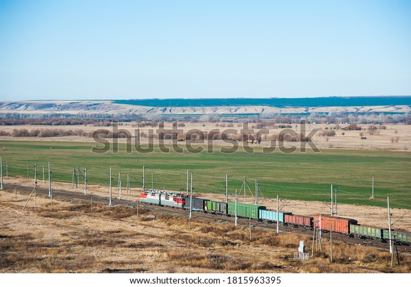 Freight train crossing through railroad\
station. Railway freight cars and tank\
cars