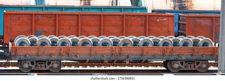 Freight Train Loaded With New Spare Parts, Railway Wheels For Locomotives Or Train Cars. Freight Car On Rails. Train Wheels, Wagon Axle. Supply Of Spare Wheels For Trains