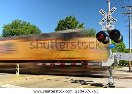 Freight train in motion at crossing gate