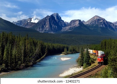 Freight Train Moving Along Bow River In Rocky Mountains Range, Canada