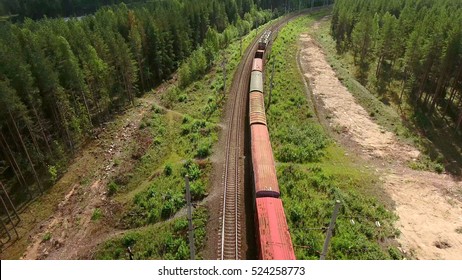 Freight Train Passing At The Double Line Railway With Freight Wagons. Evergreen Forest Of Karelia, Russia. View From Above