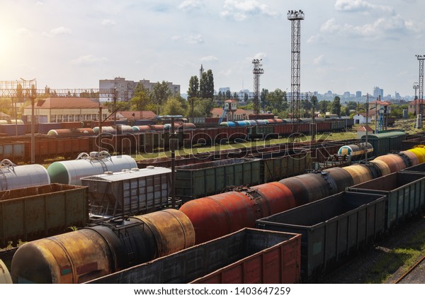 Freight trains on city cargo terminal.\
Railways in train parking. Arain arrived at the station. Cargo\
train platform with freight train container at depot in port use\
for export logistics\
background.