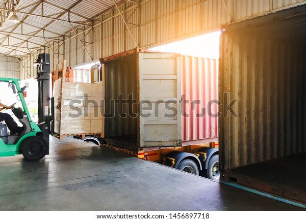 freight\
transportation, cargo courier shipment. forklift driver unloading\
cargo pallets into a truck\
container.
