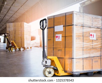 Freight transportation, Logistic warehouse. Hand pallet truck with cardboard boxes stacked on pallet at docks. cargo load into a truck.
