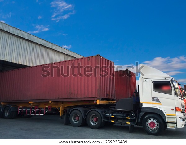 Freight transportation. Truck\
with container shipping parked in Depot warehouse\
distribution.