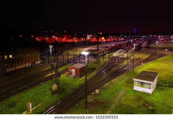 Freight yard at night with grass tracks and\
parked trains for\
maneuvering