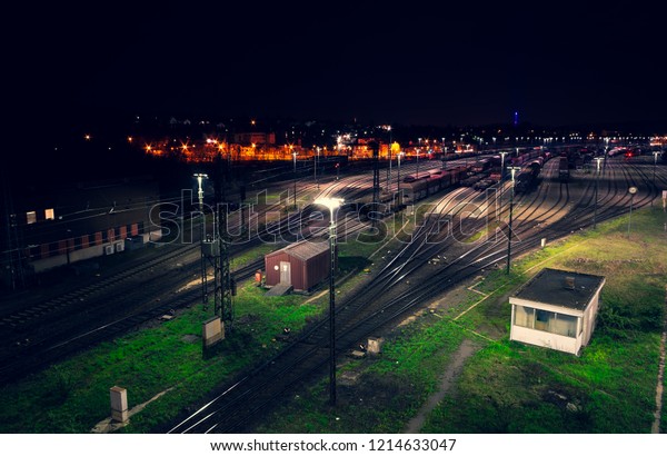 Freight yard at night with grass tracks and\
parked trains for\
maneuvering
