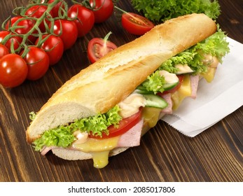 French Baguette with Ham and Cheese on wooden background. 