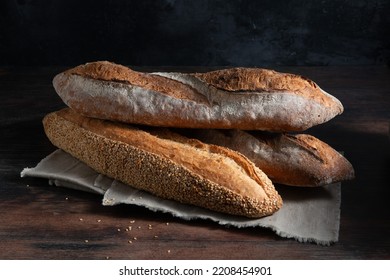 French baguettes on a wooden dark background. Side view.