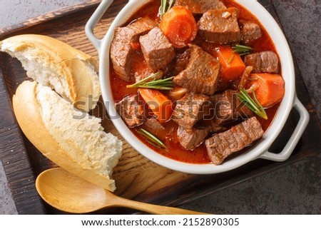 French beef stew in red wine known as daube de boeuf Provencal closeup in the wooden tray on the table. Horizontal top view from above
