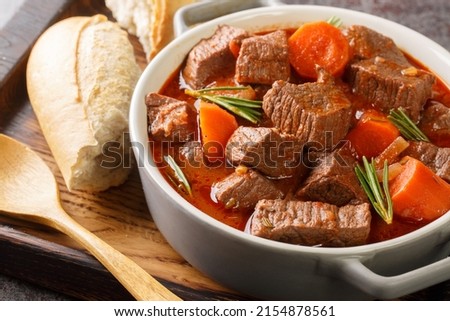 French beef stew in red wine known as daube de boeuf Provencal closeup in the wooden tray on the table. Horizontal
