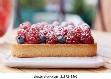 French Blueberry And Raspberry Tart On White Ceramic Plate. Top View Food. Aesthetic Food.