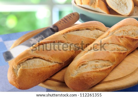 French bread baguettes on bread board and bread-knife