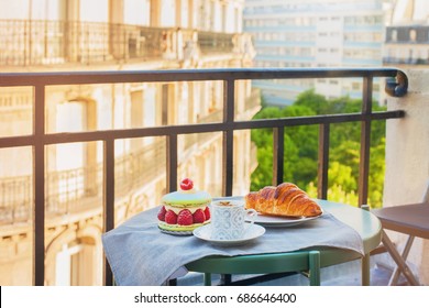 French breakfast with a view. Cup of coffee espresso, croissant and big macaron with raspberries. - Powered by Shutterstock