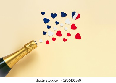 French champagne bottle and hearts in the colors of the French flag, 14 July Bastille Day and French National Holiday concept, top view