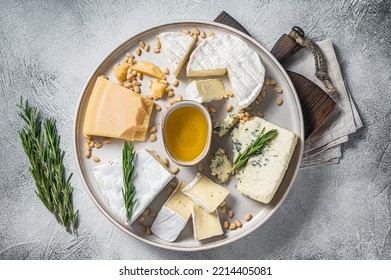 French Cheese platter with camembert, brie, Gorgonzola, parmesan, honey, nuts and herbs. White background. Top view.