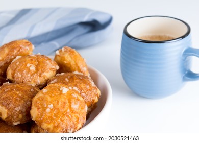 french chouquettes puffs with perles of sugar on plate with blue cup of coffee. Choux pastry Classic French bakeries. 