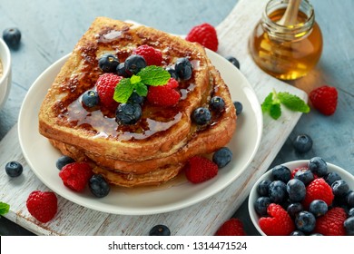 French cinnamon toast with blueberries, raspberries, maple syrup and coffee. morning breakfast - Shutterstock ID 1314471524