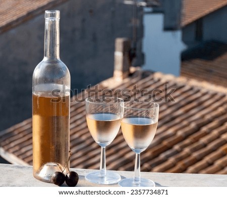French cold rose dry wine from Provence in two glasses in sunny day with view on old roofs of Arles town in sunny day