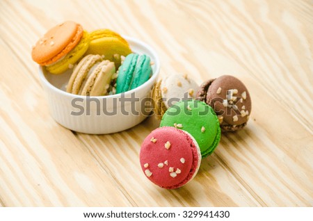  lot of french colorful macarons on a woody floor