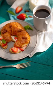 French Croissant With Fresh Strawberries, Mint Leaves, Almonds And A Cup Of Fragrant Coffee. Beautiful Still Life. Turquoise Background. It's Not Like People. Advertising, Café, Restaurant, Hotel.