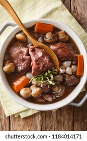 French Cuisine: Coq Au Vin Cock In Wine Close-up In A Bowl On The Table. Vertical Top View From Above
