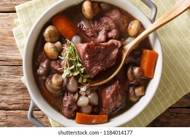 French Cuisine: Coq Au Vin Cock In Wine Close-up In A Bowl On The Table. Horizontal Top View From Above
