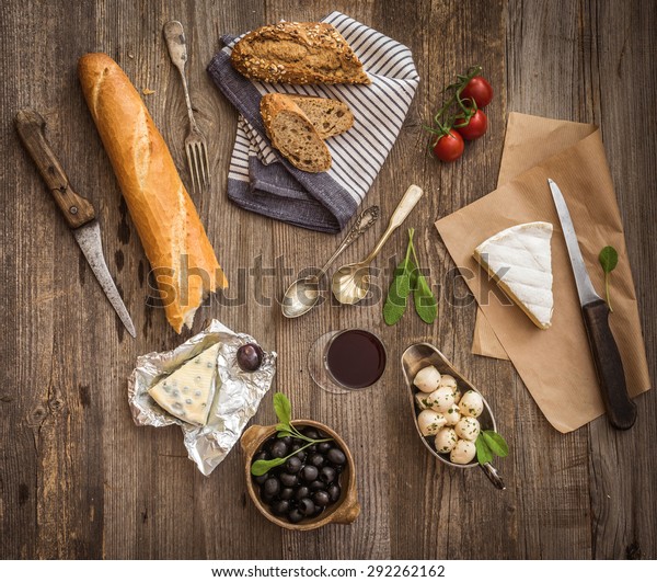French cuisine. Different types of cheese,\
wine and other ingredients on a wooden\
table