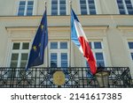 French and European Union flags and the emblem of the French Consulate General in Krakow, Poland on a sunny day