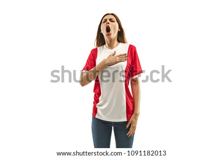 French female fan celebrating on white background. The young woman in soccer football uniform as winner standing and singing a hymn isolated at white studio. Fan, support concept. Human emotions