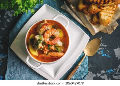 French fish soup Bouillabaisse with seafood, salmon fillet, shrimp, rich flavor, delicious dinner in a white beautiful plate. - Shutterstock ID 1060429079